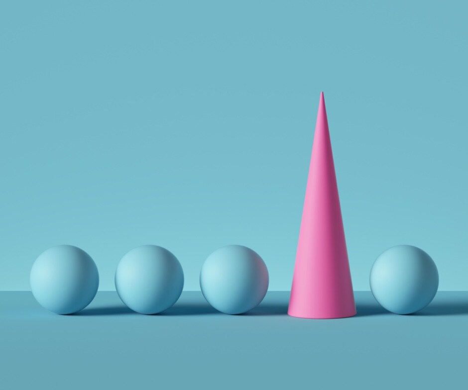 blue background with 4 blue spheres horizontally aligned and a pink cone nestled between the 3rd and 4th sphere