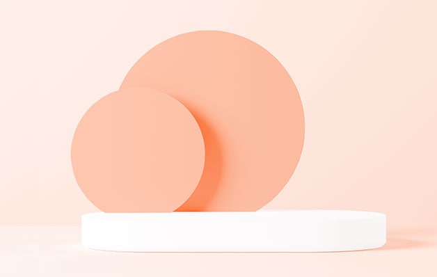two peach circles on a white platform in front of light peach background