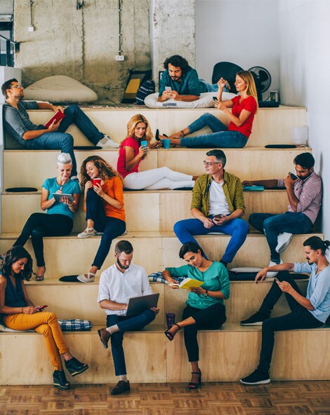 gruppo di persone sedute sulle scale che guardano oggetti che tengono in mano
