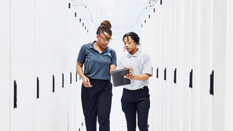 Two People walking and discussing by looking into the tab