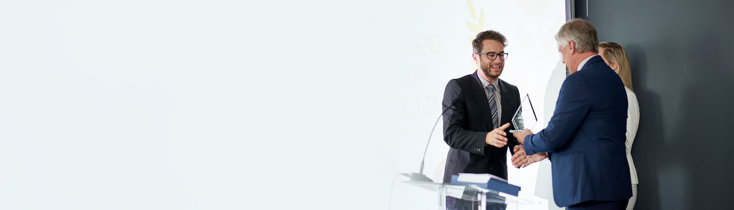 Deux experts recevant un prix d'un intervenant sur un podium