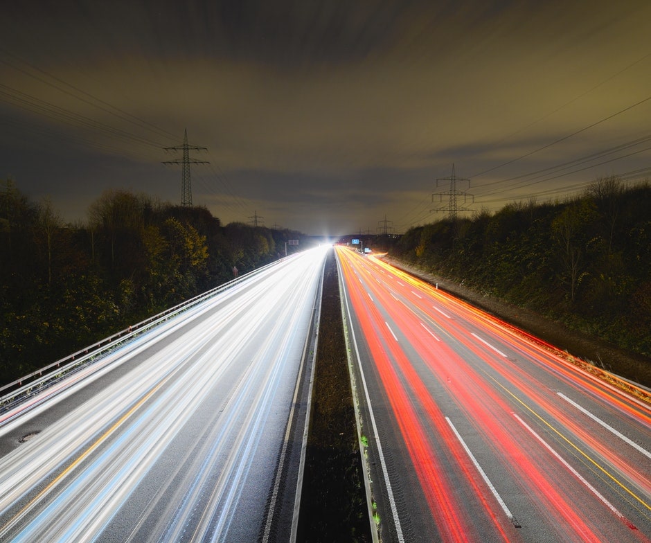 time-lapse image of highway showing streaks of light