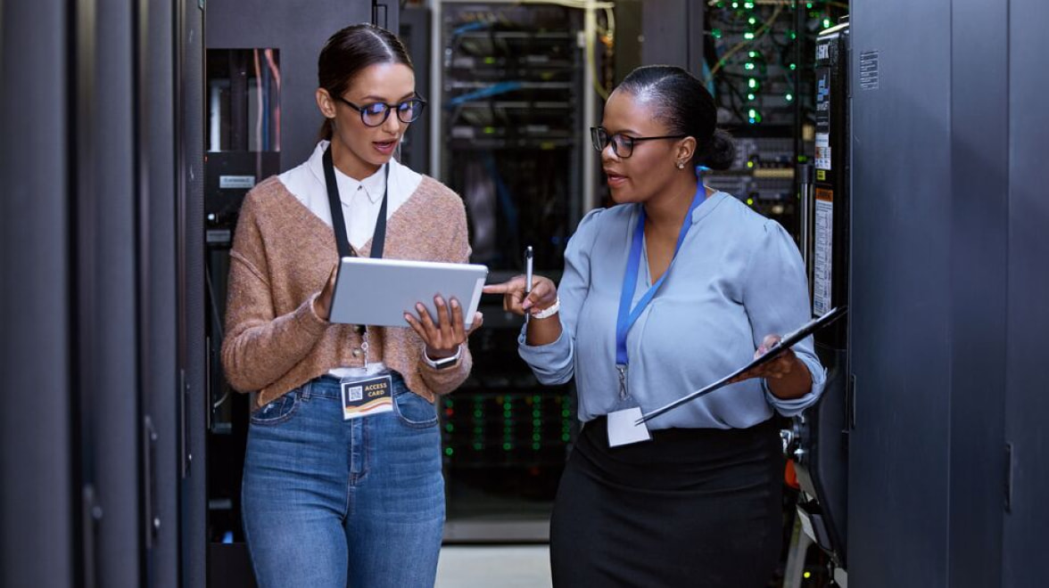 Women walking through server room discussing a report