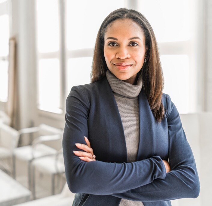 professional woman with arms crossed, slight smile