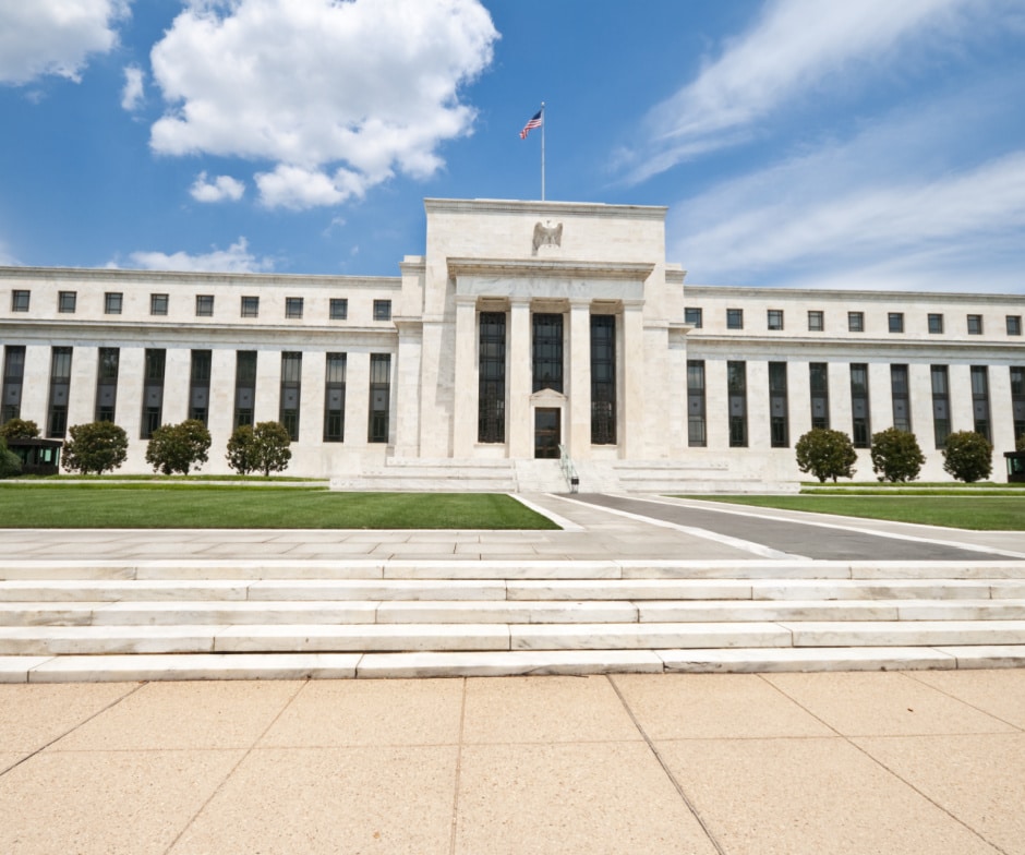 front view of a building with pillars and grass in front of the building