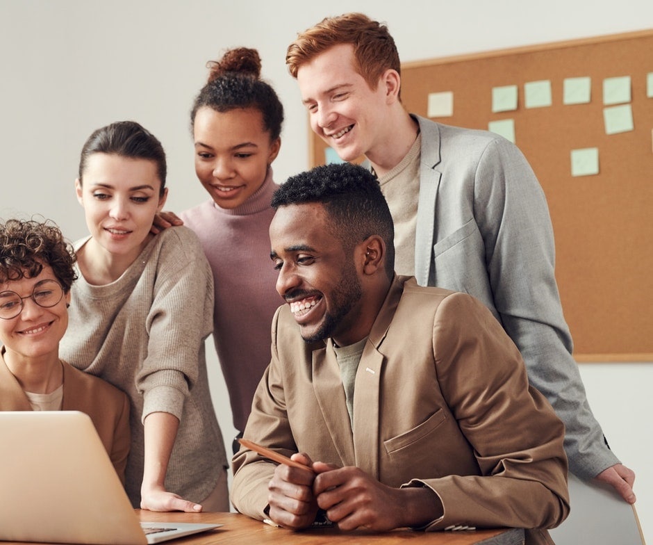 people collaborating in front of a laptop