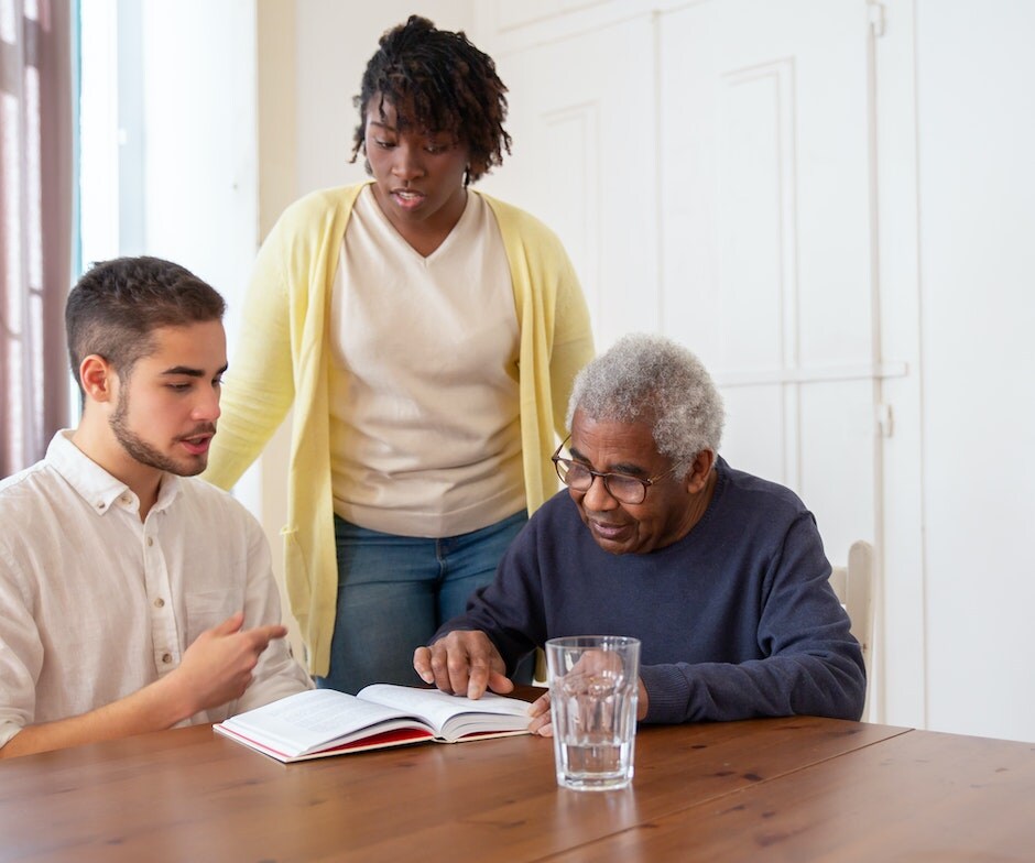 three people looking over a book together