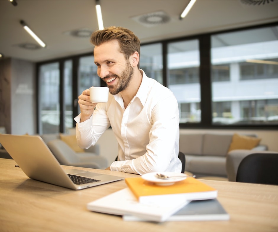 person drinking coffee at their desk