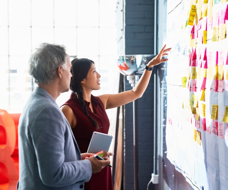 two people looking at a project board together