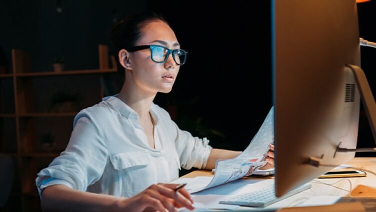 Personne portant des lunettes travaillant sur des écrans