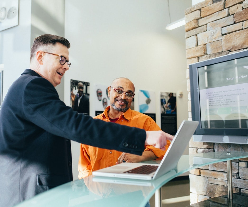 two men working in front of a laptop