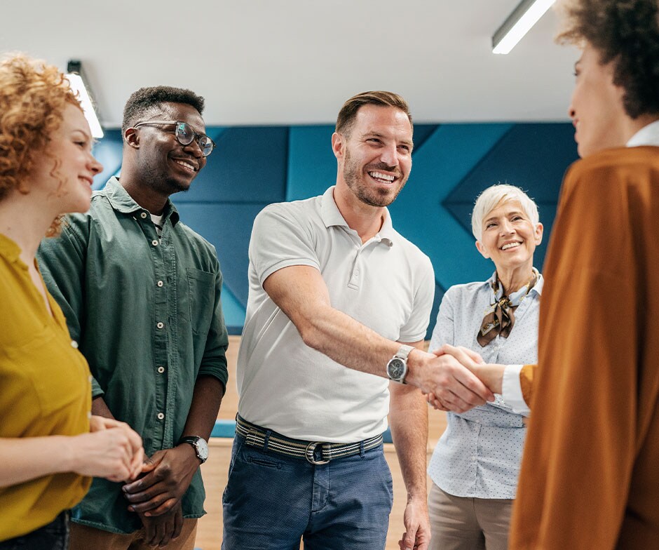 Grupo de personas juntas, dos dándose la mano