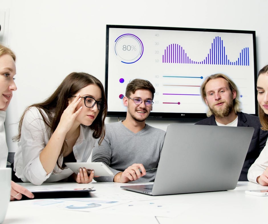employees sitting inside conference room and looking at data