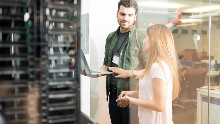 people with laptop inside data center room and discussing