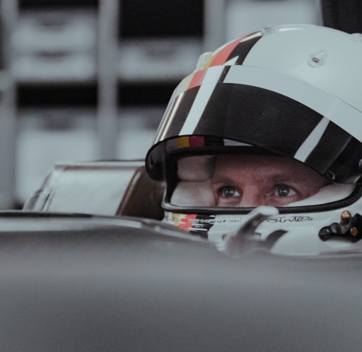 man wearing a racing helmet in formula 1 car