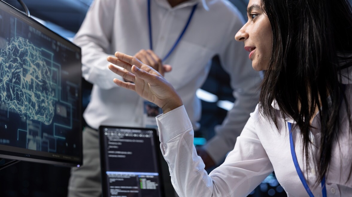 Dos personas hablando entre sí mirando el monitor