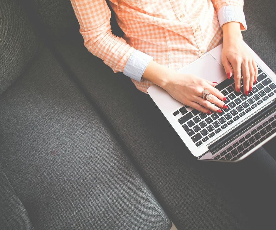 Person working on laptop whil sitting on couch