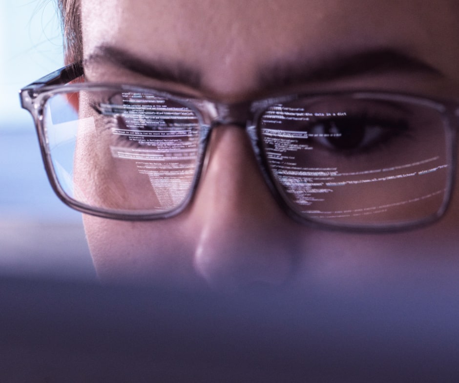 person wearing glasses and looking at monitor and analyzing