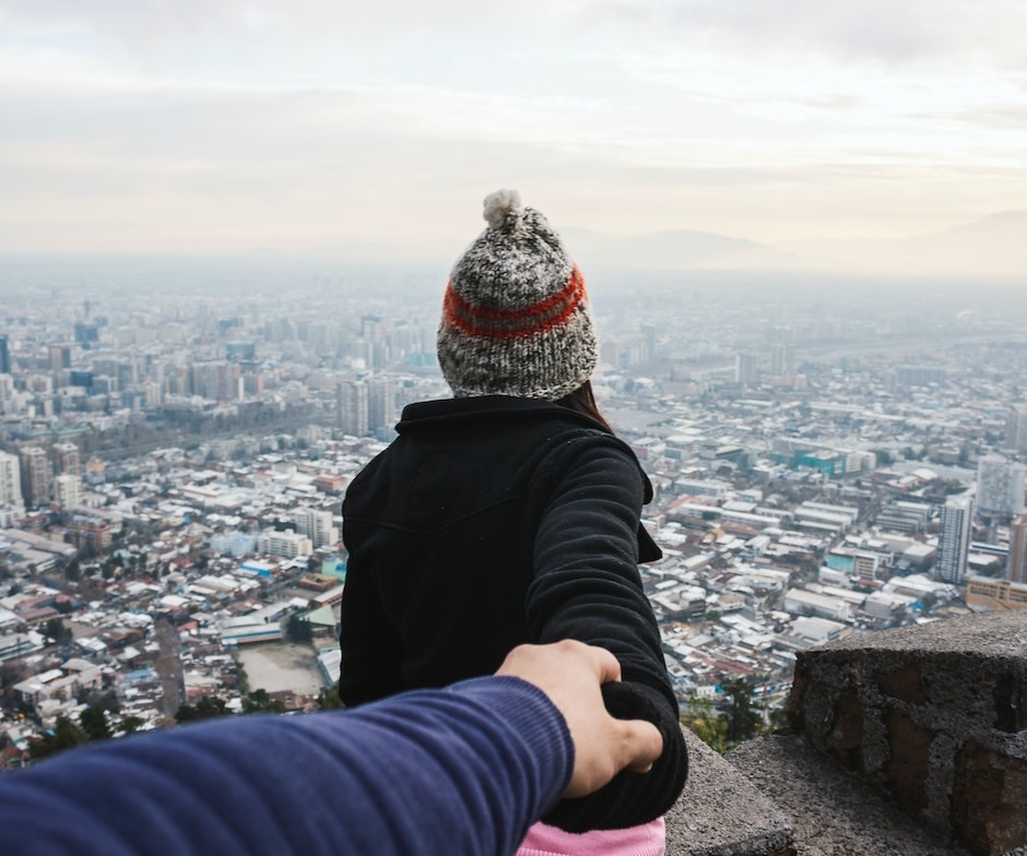 two people holding hands above a city