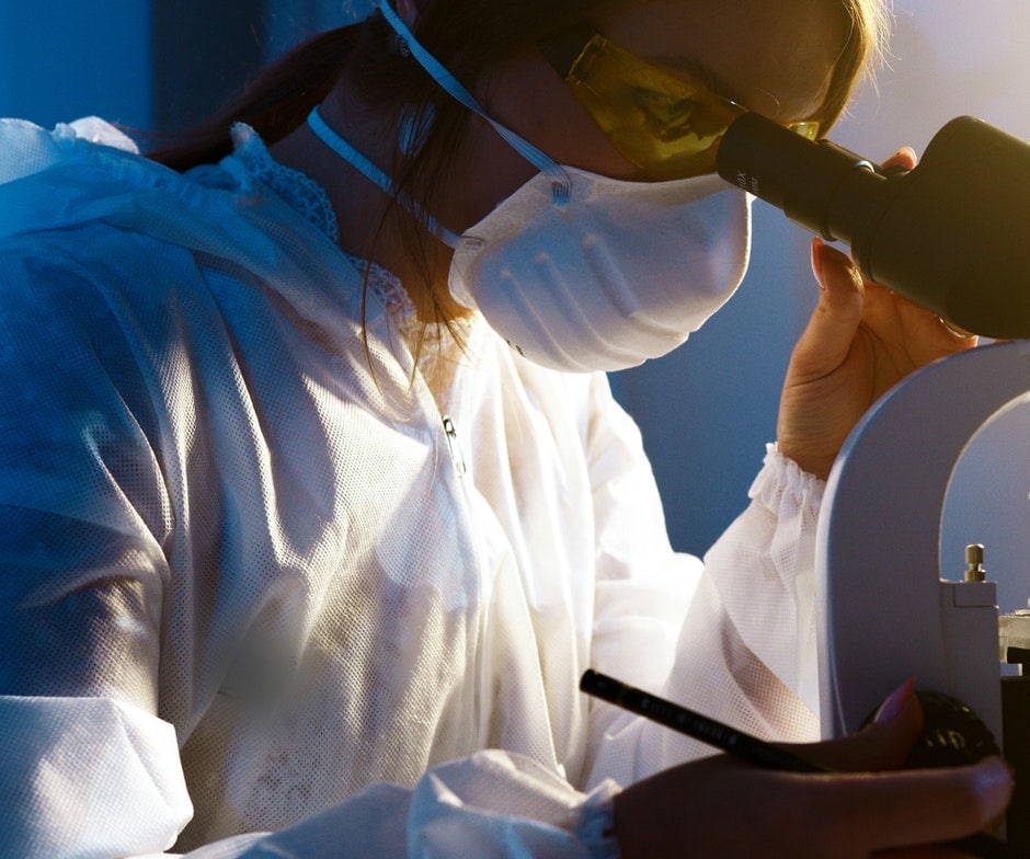 medical worker looking in microscope