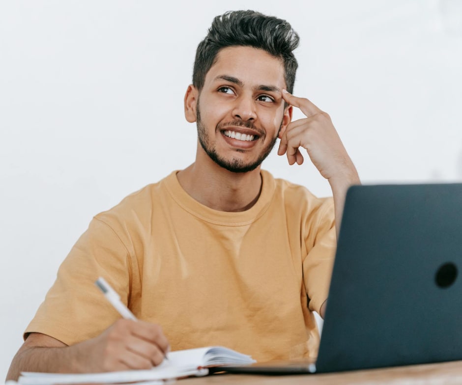 man workingon the laptop and smiling