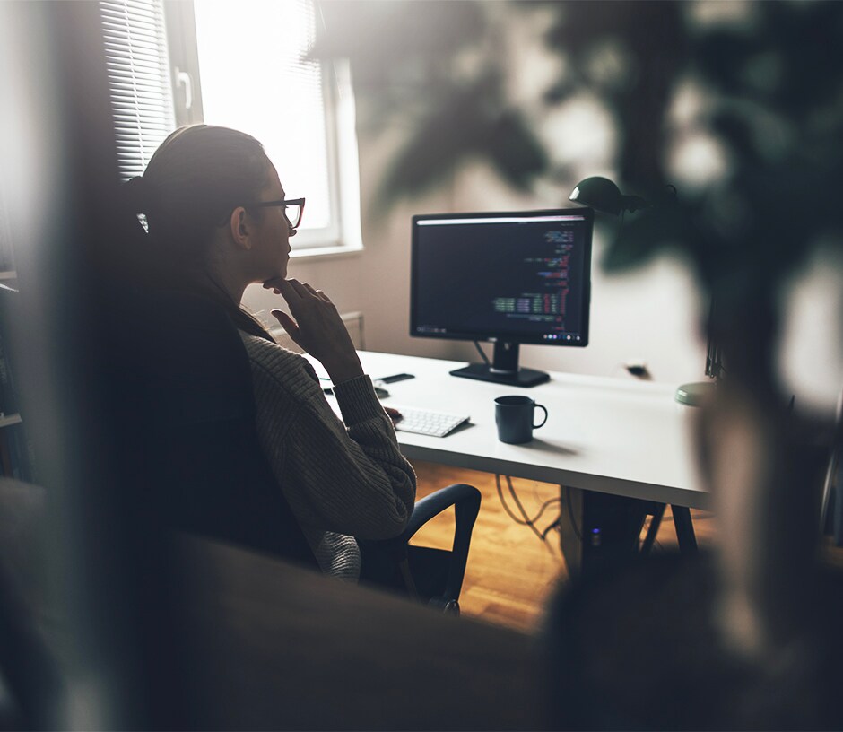 pessoa que olha para uma tela do computador em seu escritório home