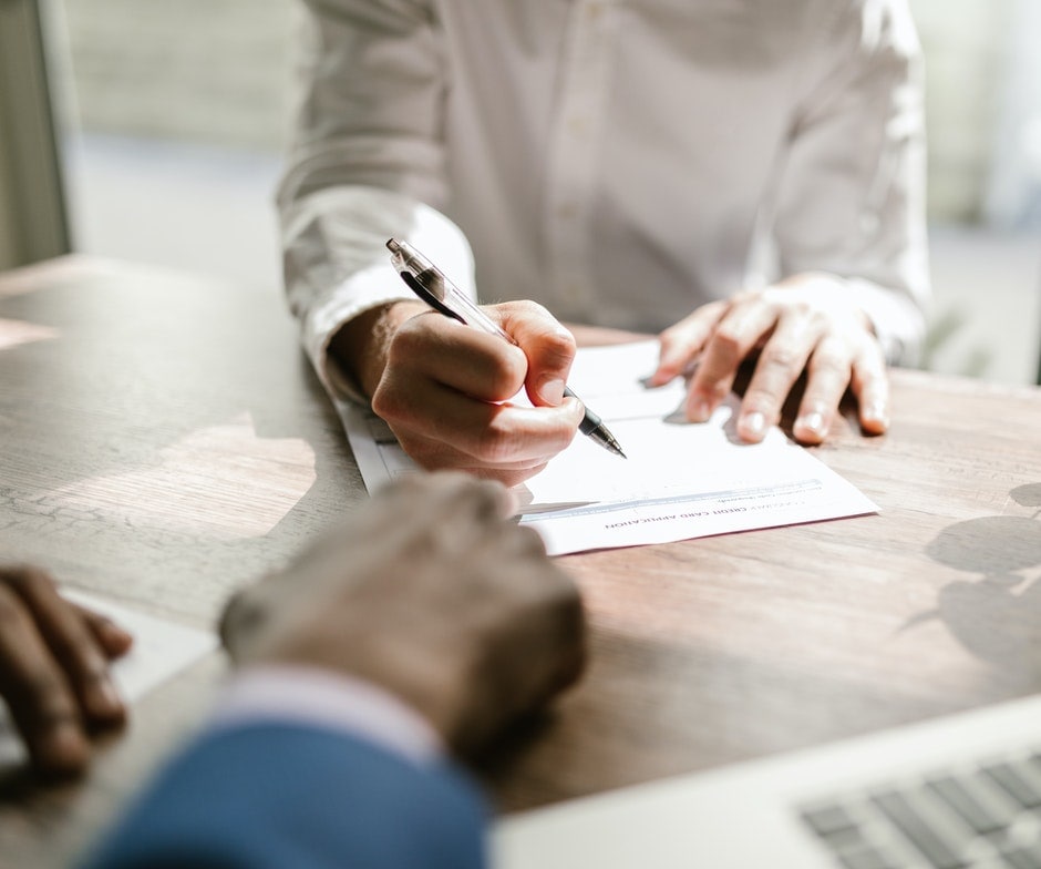 hands signing paperwork
