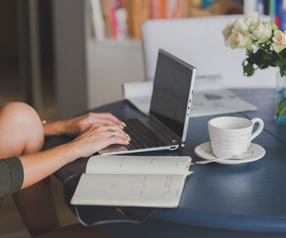 person working on a laptop at a kitchen table