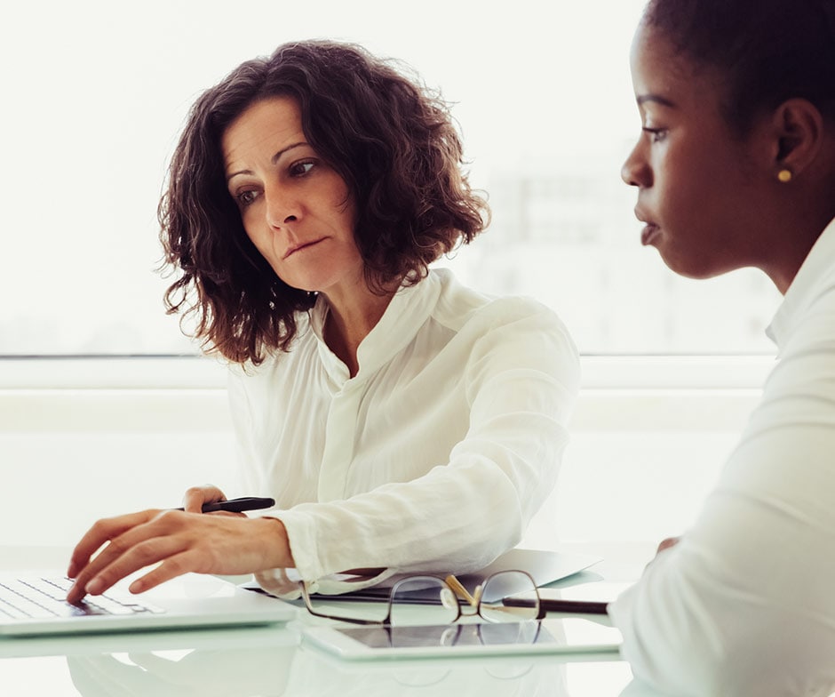 Dos mujeres mirando juntas el portátil