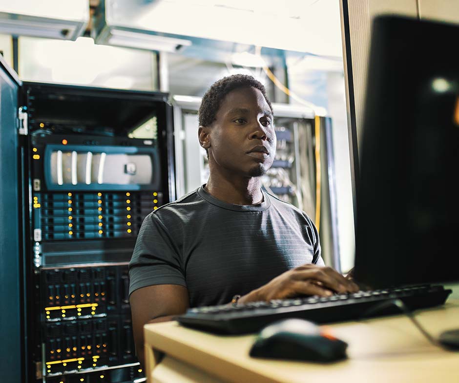 person working with laptop in datacenter