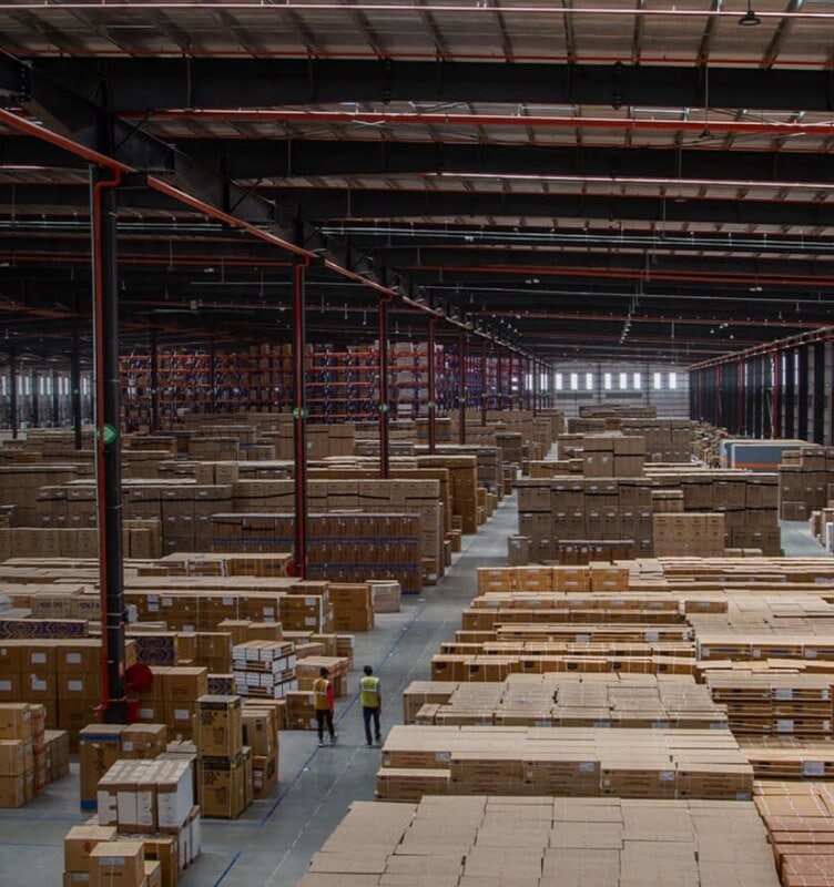 Two men inside a large Mahindra warehouse