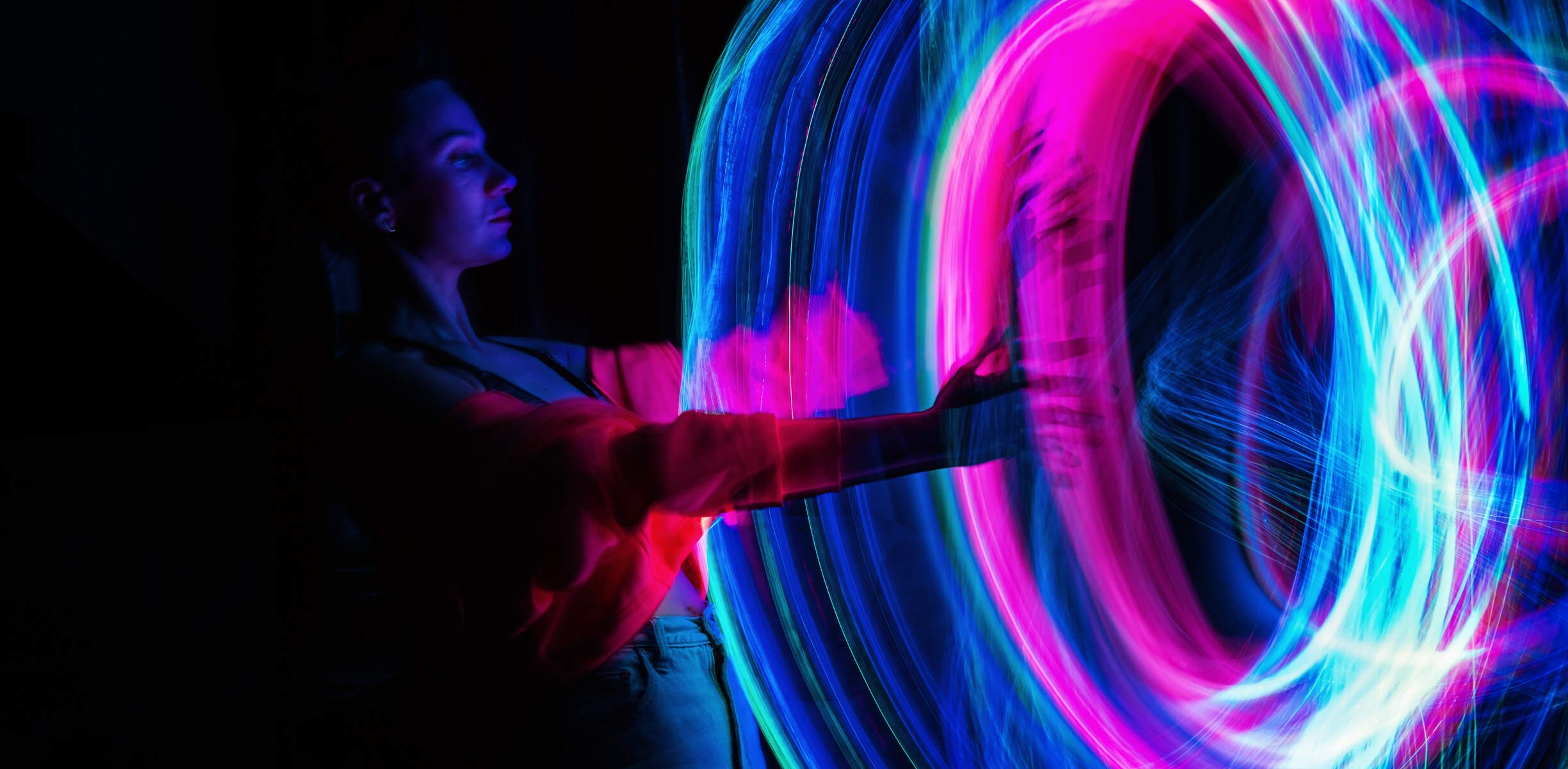 donna che raggiunge un anello di luce multicolore e brillante
