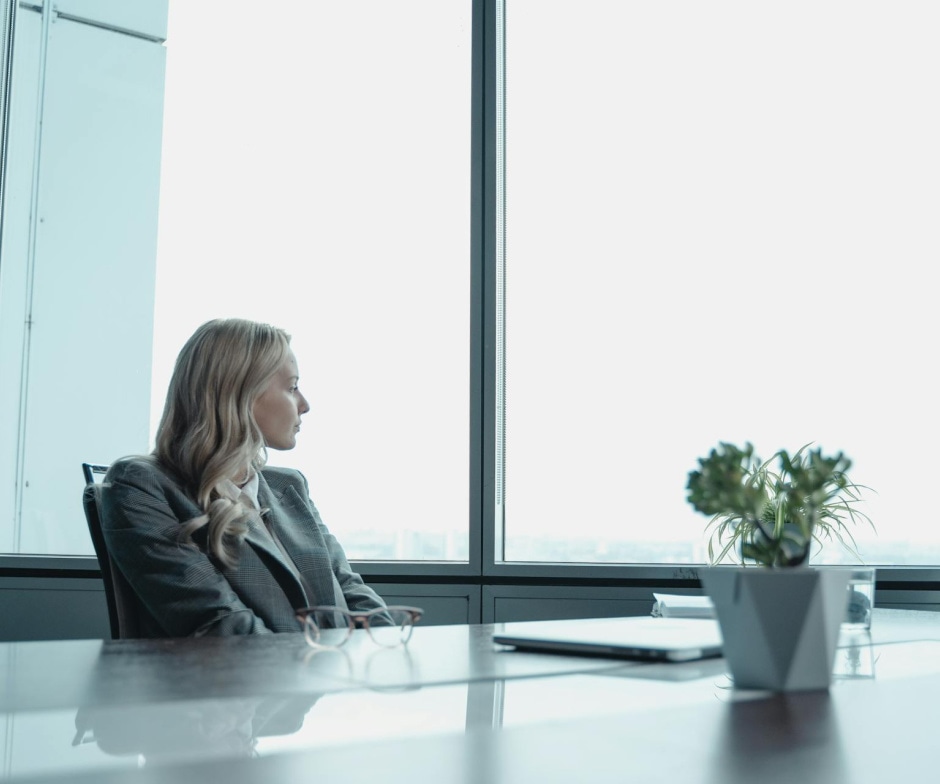 Woman sitting at table looking out the window
