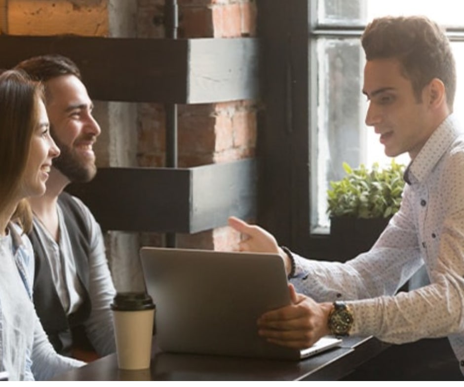 a couple talking to a young man over a laptop