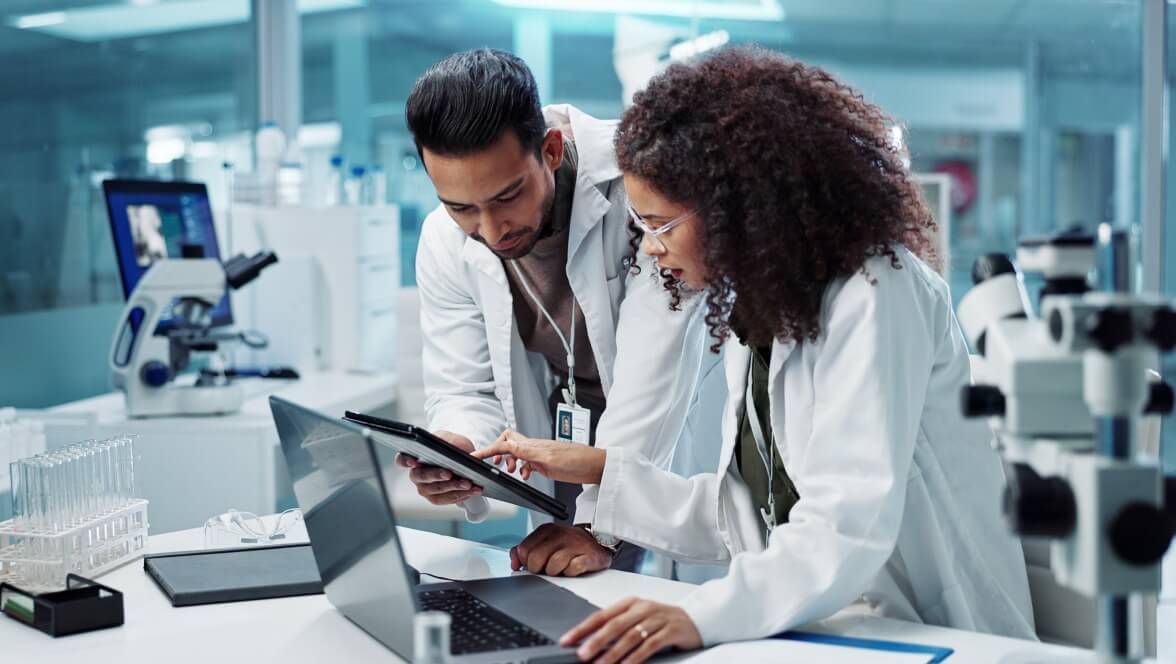 two professionals looking at electronic tablet and analyzing