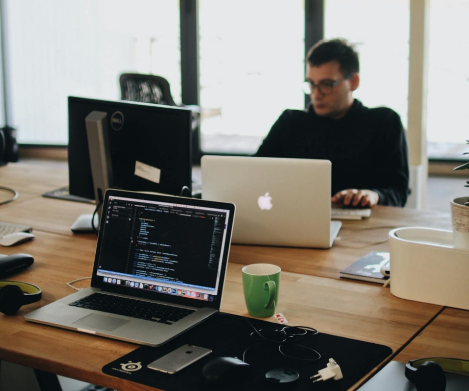 person sitting in conference room and looking at laptop