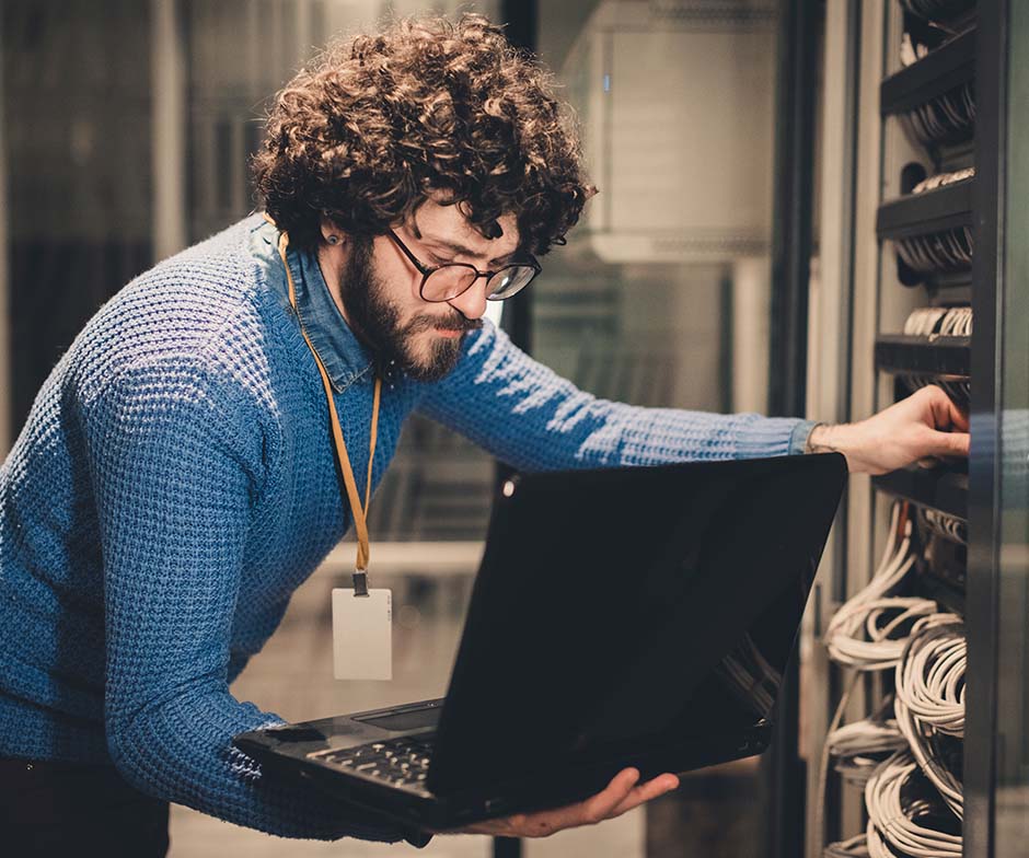 person working with laptop in datacenter