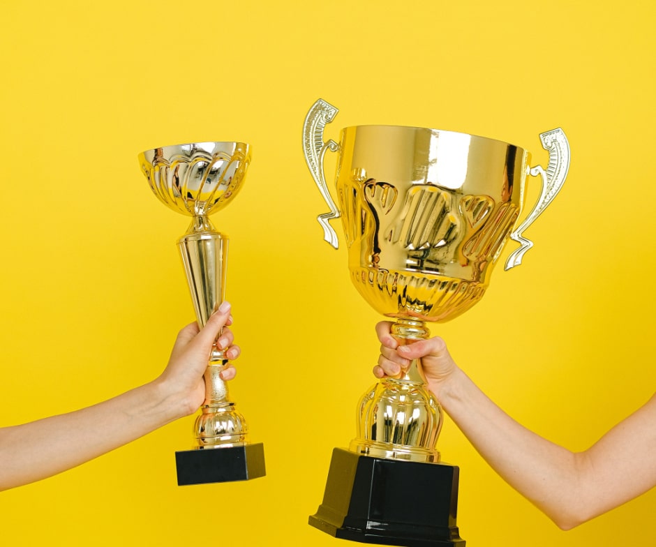 two people holding trophies