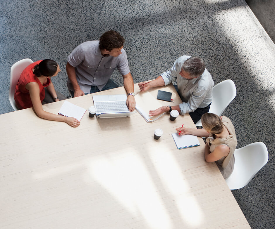 quatre personnes qui discutent de travail autour d'une table
