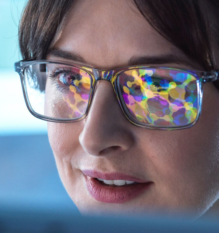 Close-up view of eyeglasses worn by a person working at a computer.