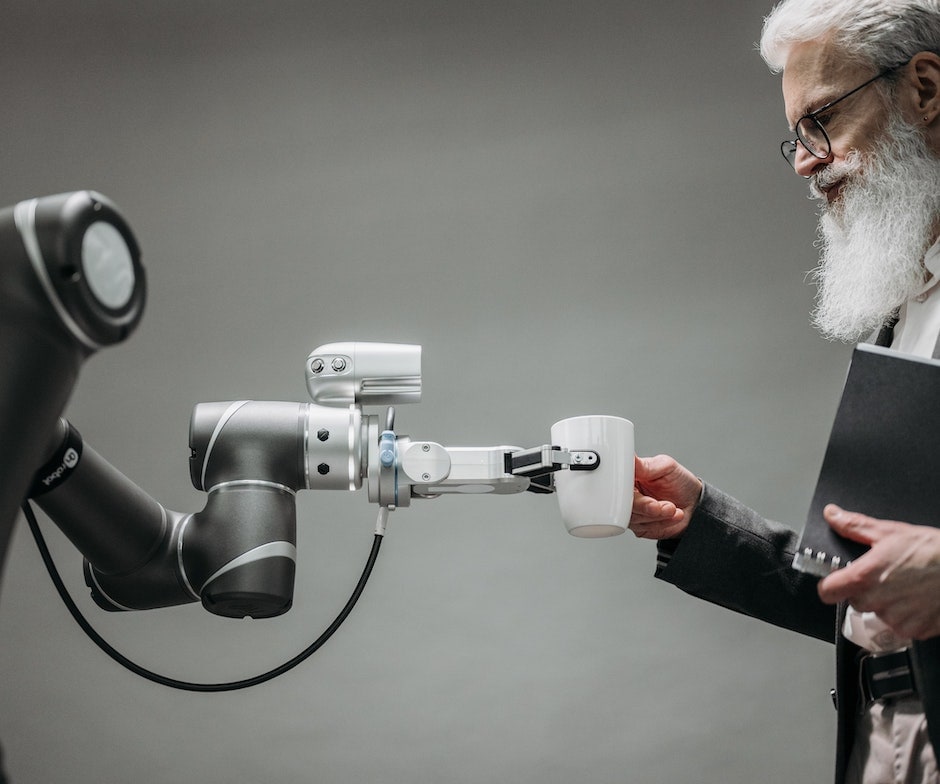 person taking coffee cup from robotic arm machine