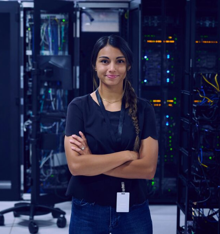 Woman standing among servers in room with arms crossed