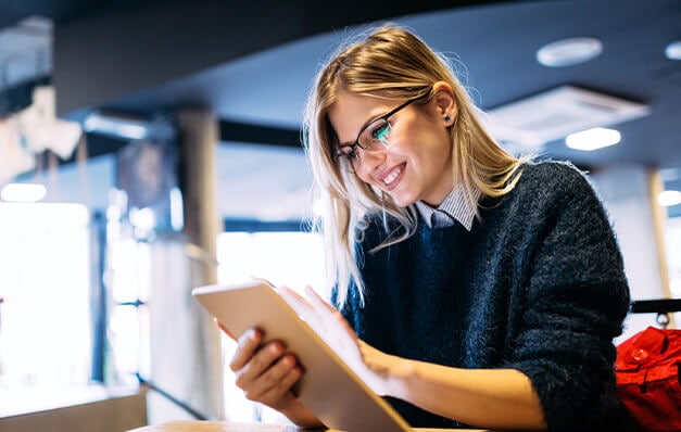 Person with glasses writing on notepad