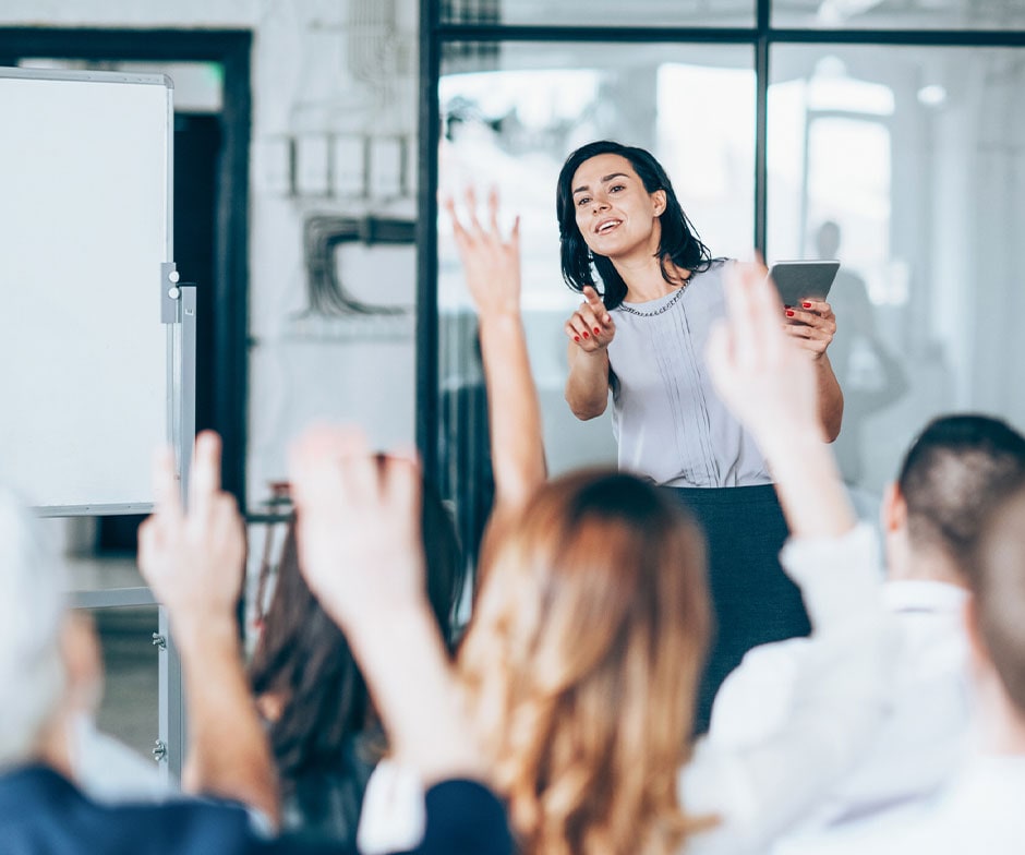 people raising their hands in meeting
