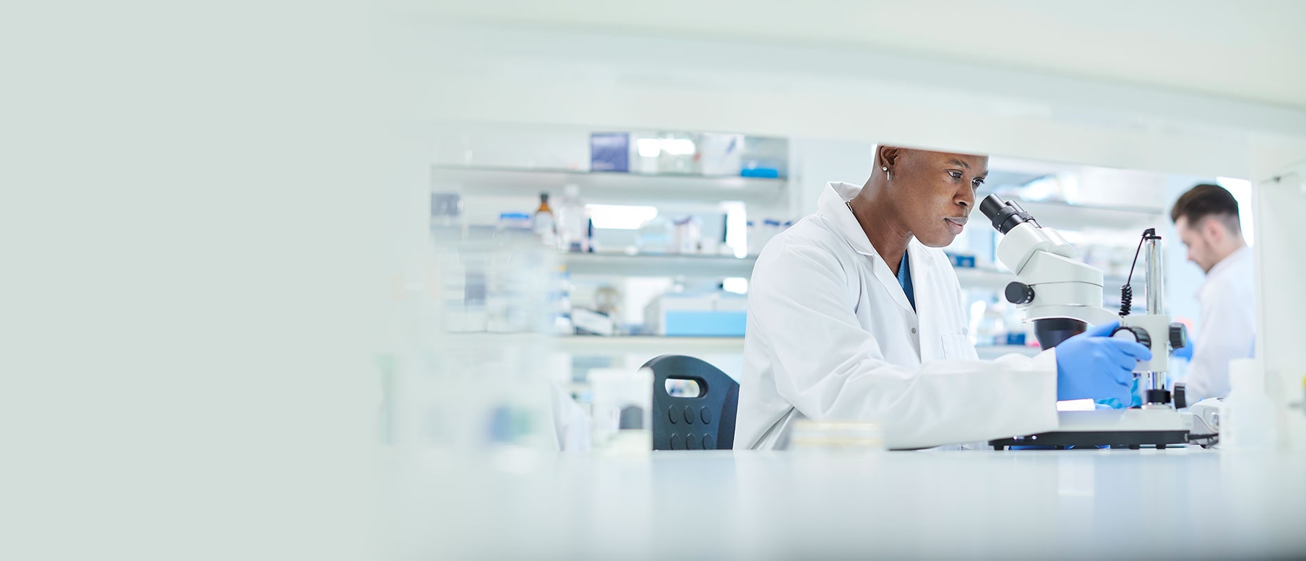 Lab worker looking into microscope
