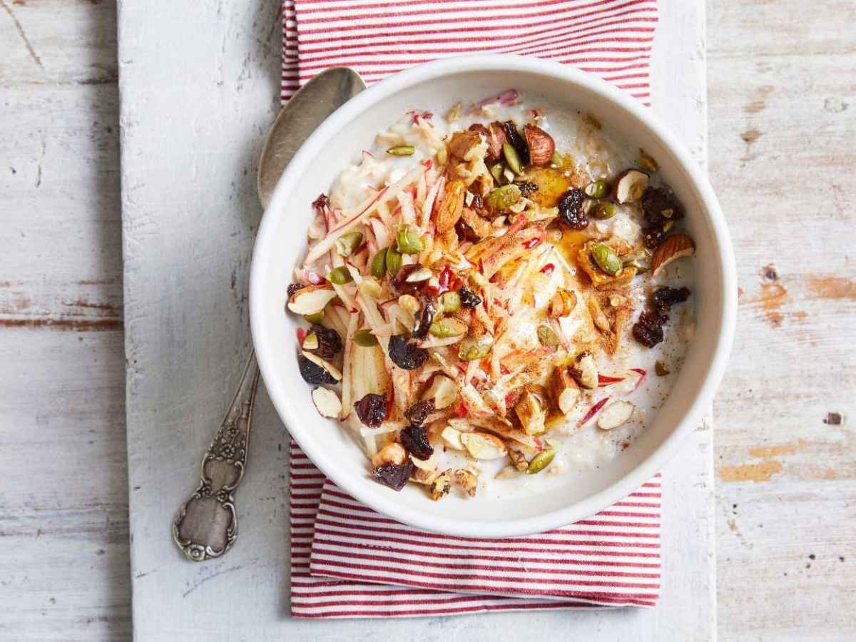 Apple and honey nut crumble oats served warm in a bowl with topping