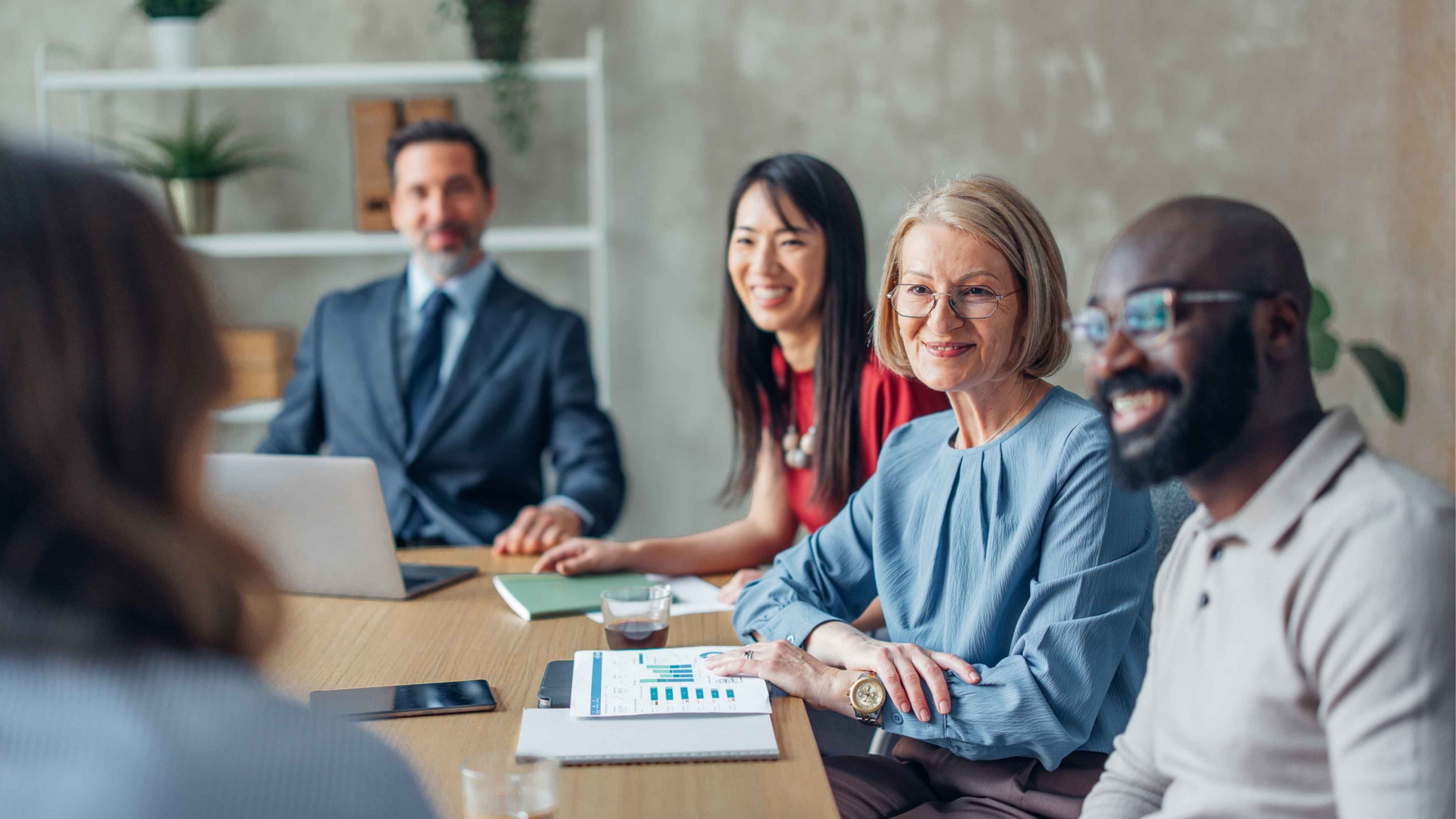 A group of people sitting in business meeting