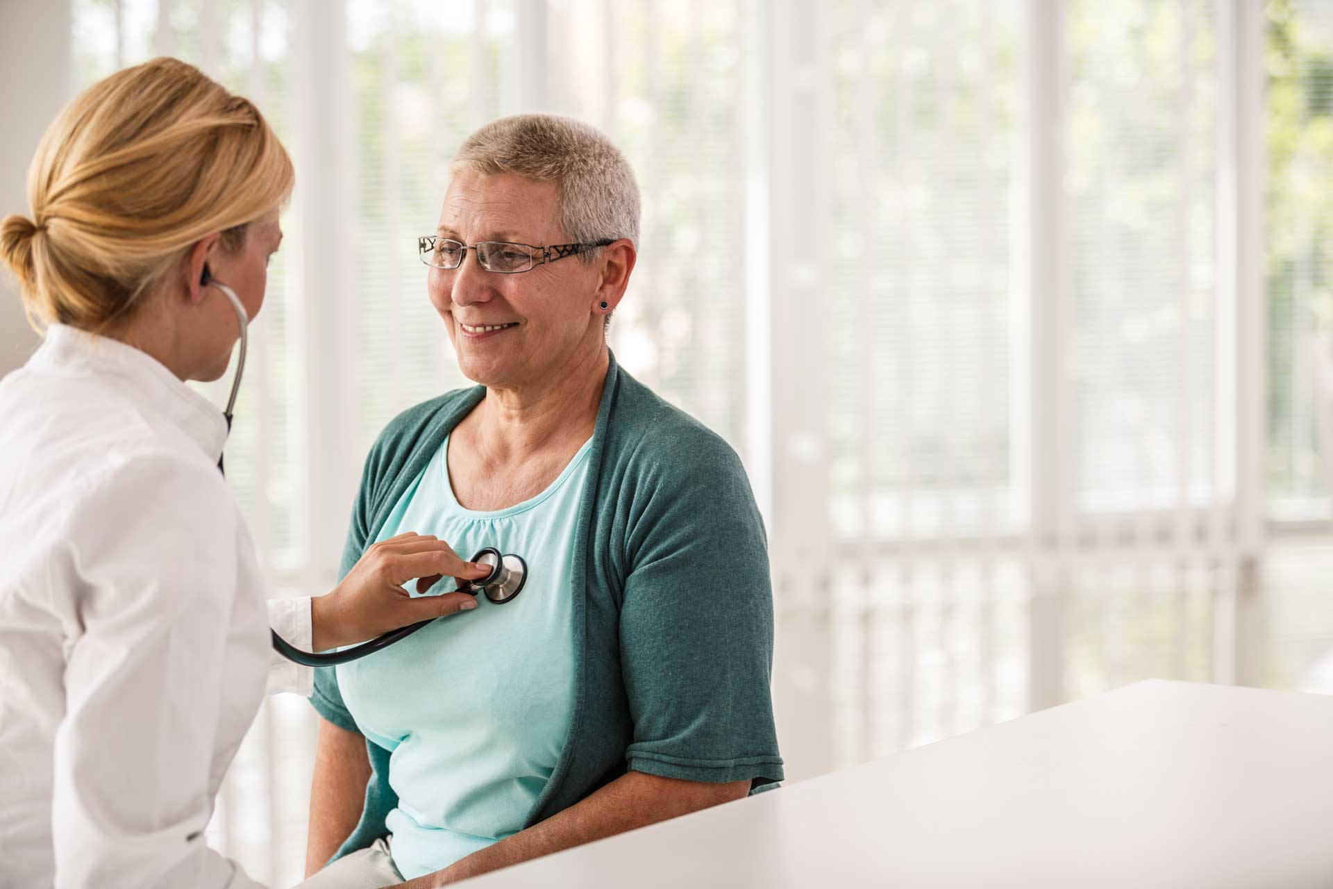  Female doctor using stethoscope while examining patient.