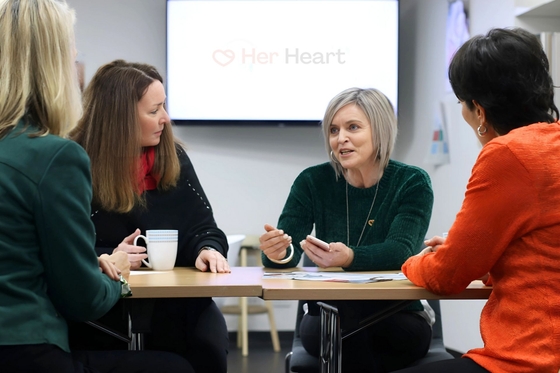 A group of women sitting around a table, discussion heart health with the Her Heart CEO