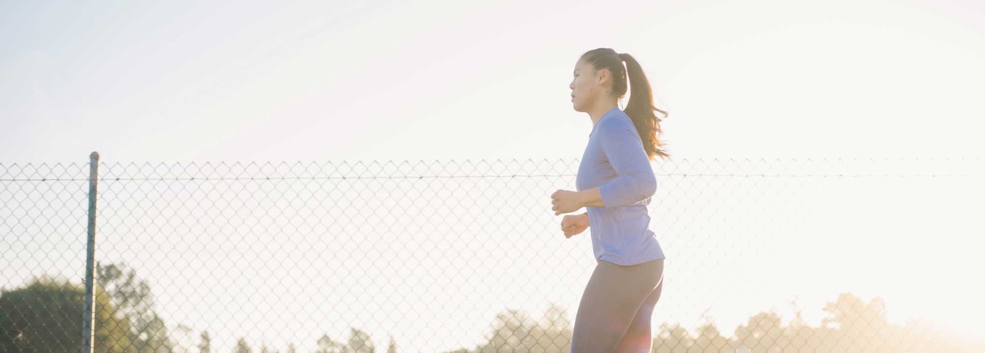 Woman in exercise / active wear jogging / exercising outdoors